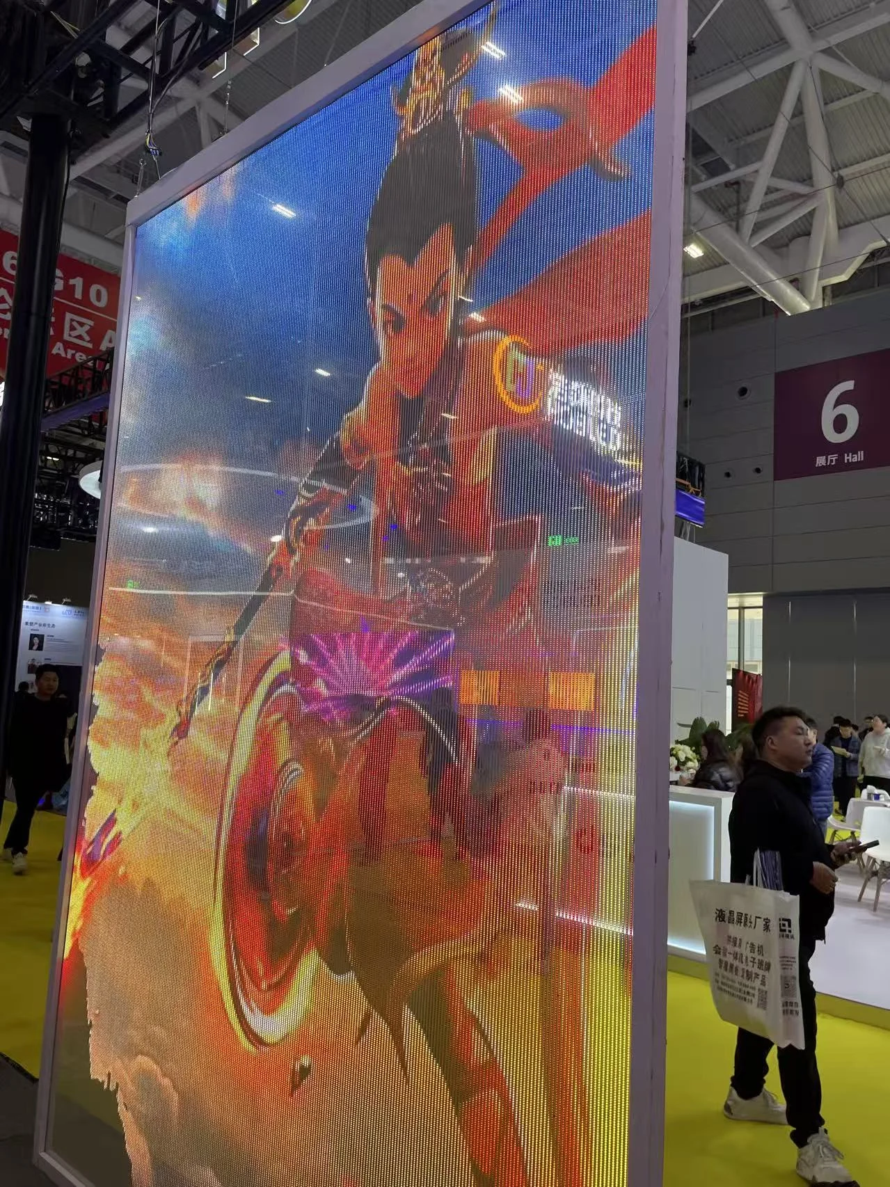 Large transparent or mesh-style LED screen displaying animated content at the ISLE 2025 exhibition