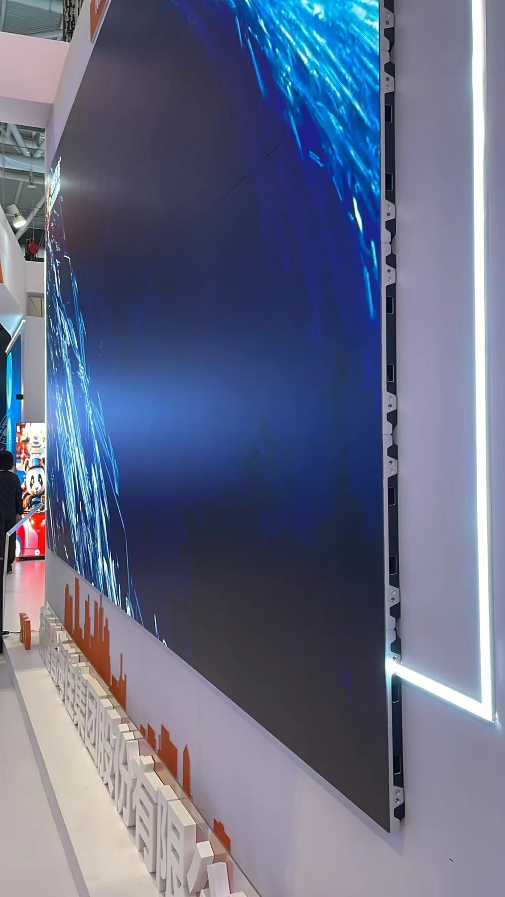 Side view of a large modular LED display showing cabinet depth and installation structure at ISLE 2025