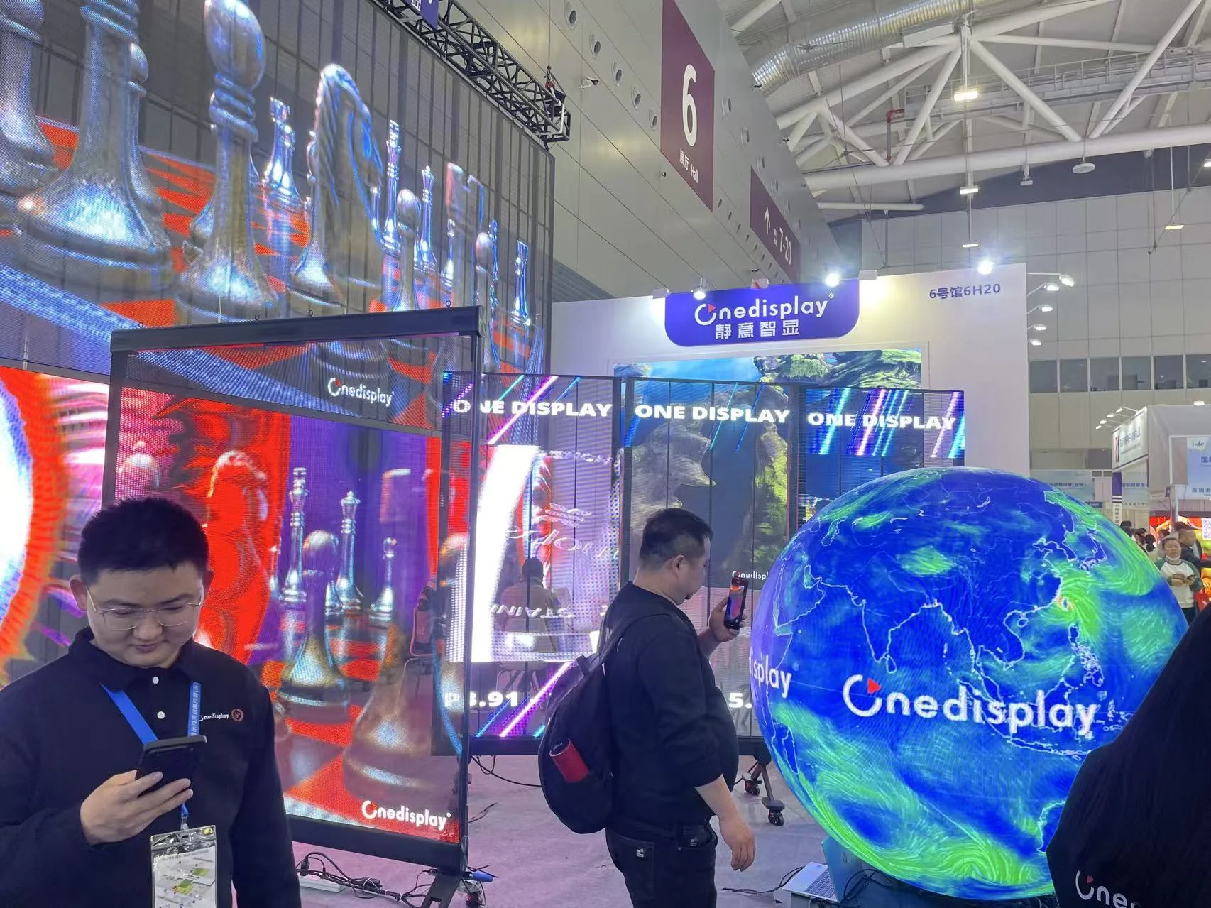 Transparent LED display panels and a spherical LED globe shown at ISLE 2025 in Shenzhen